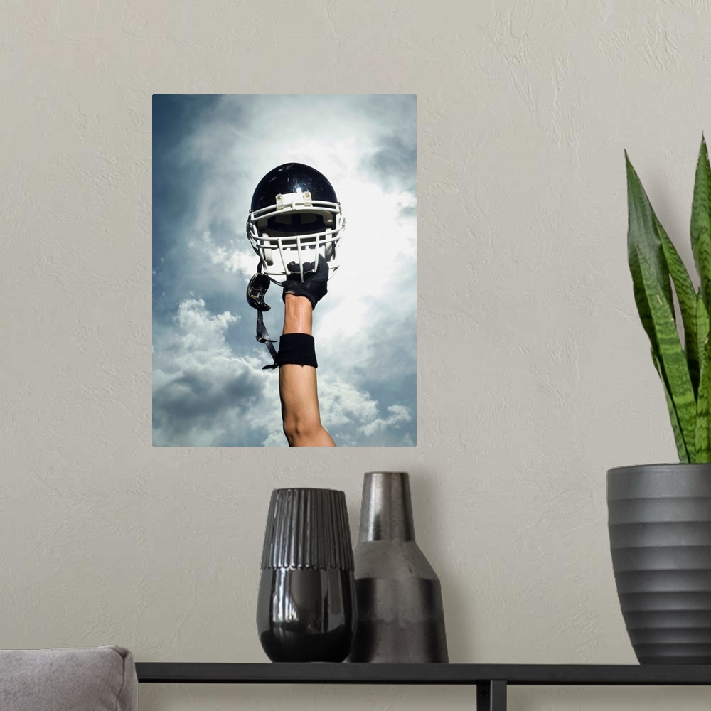 A modern room featuring Football player holding helmet in air