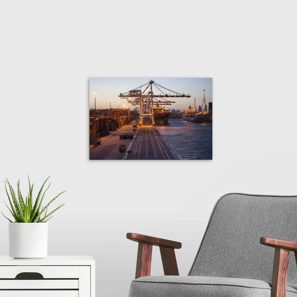 A modern room featuring Freight cranes and container ships in port at sunset, Buenos Aires, Buenos Aires, Argentina.