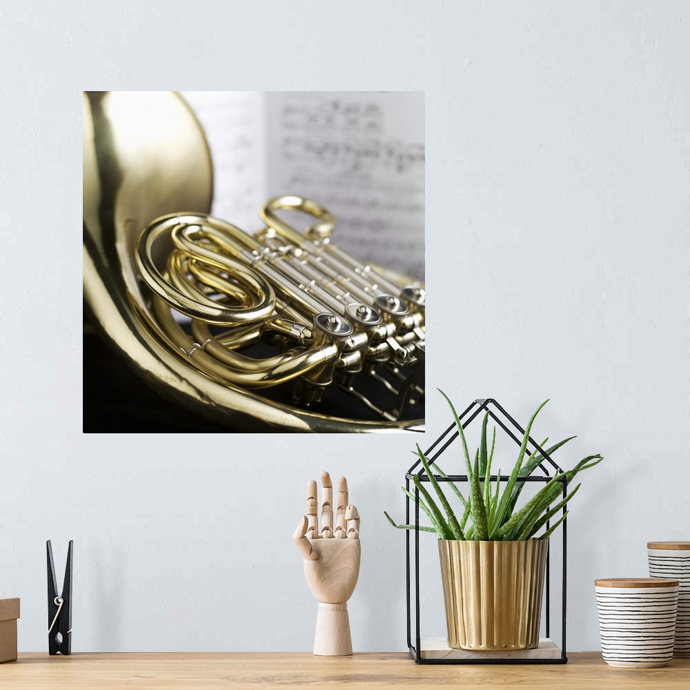 A bohemian room featuring French horn in front of sheet music