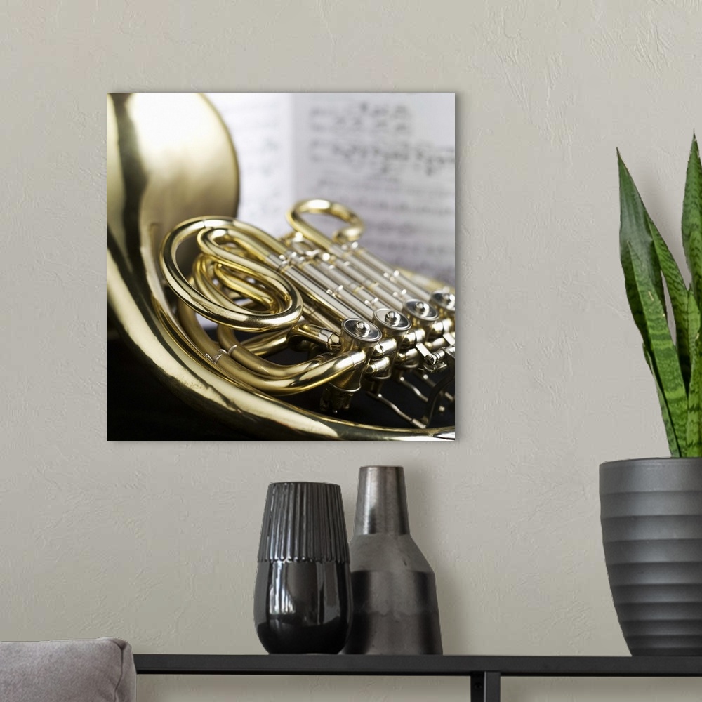 A modern room featuring French horn in front of sheet music