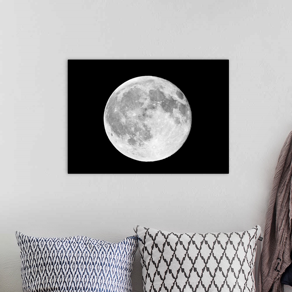 A bohemian room featuring This horizontal wall art shows a photograph of the moon against a dark, starless night sky.