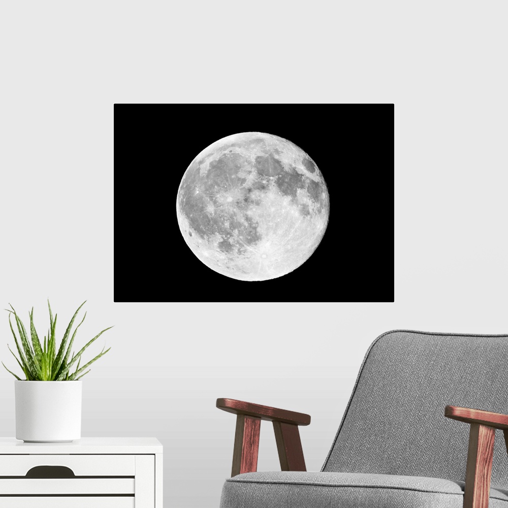A modern room featuring This horizontal wall art shows a photograph of the moon against a dark, starless night sky.