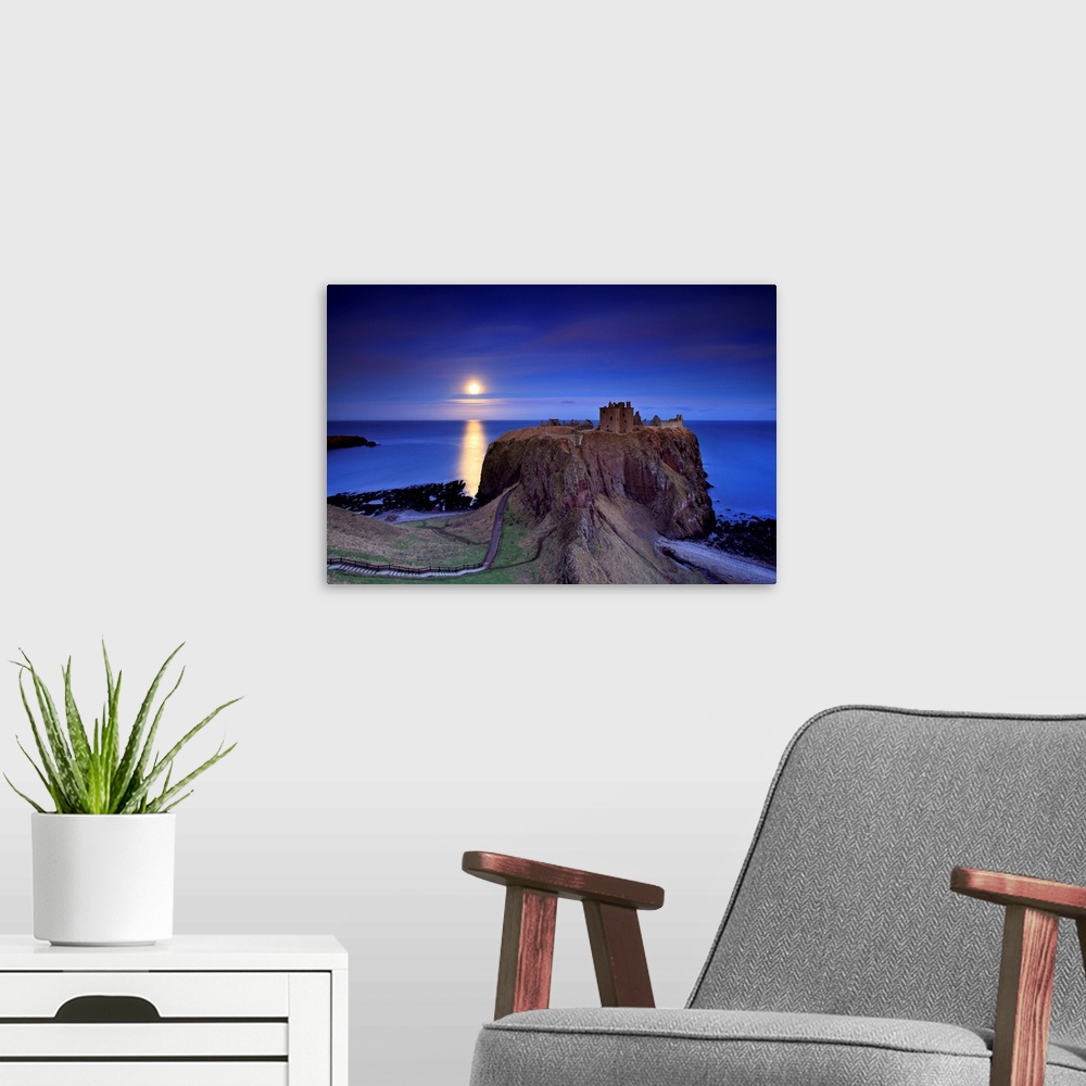 A modern room featuring Full moon is rising over calm sea and Dunnottar castle near Stonehaven on the North East coast of...