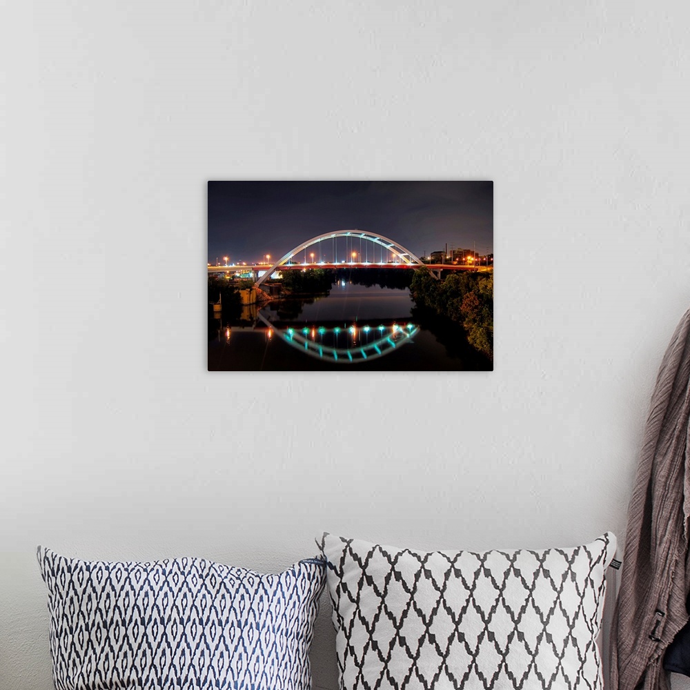 A bohemian room featuring Arch of Gateway bridge over Cumberland river in  Nashville at night.