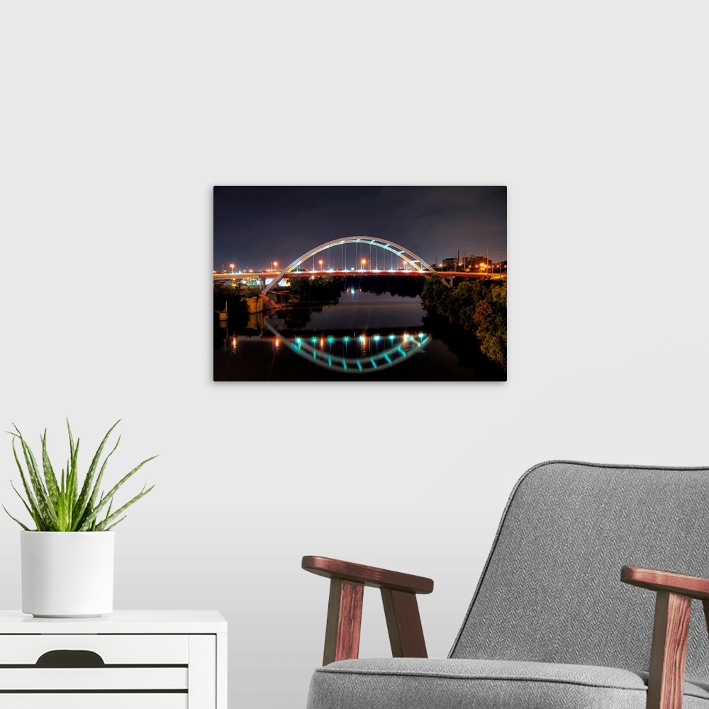 A modern room featuring Arch of Gateway bridge over Cumberland river in  Nashville at night.