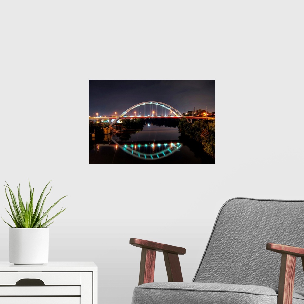 A modern room featuring Arch of Gateway bridge over Cumberland river in  Nashville at night.