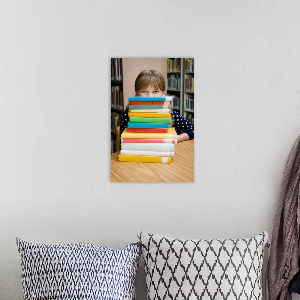 A bohemian room featuring Girl looking over stack of books