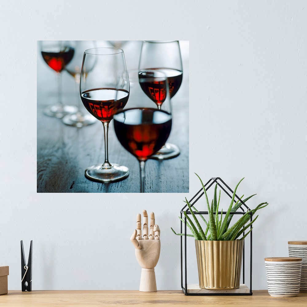 A bohemian room featuring Photograph of half full wine glasses on wooden table.
