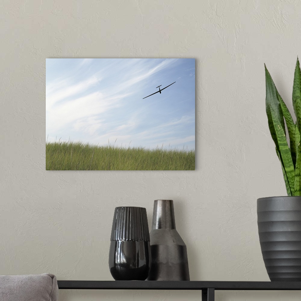 A modern room featuring Glider flying in sky with grass in foreground