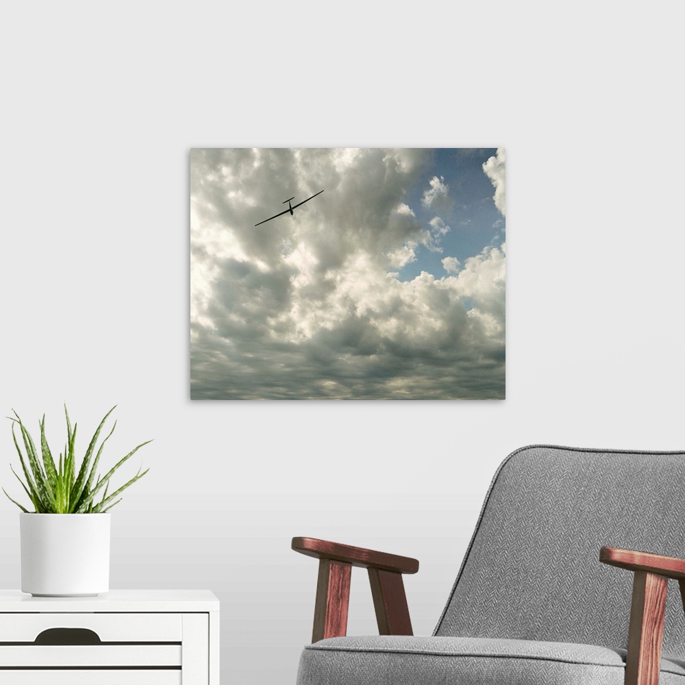 A modern room featuring Glider in flight against cloudy sky, low angle view
