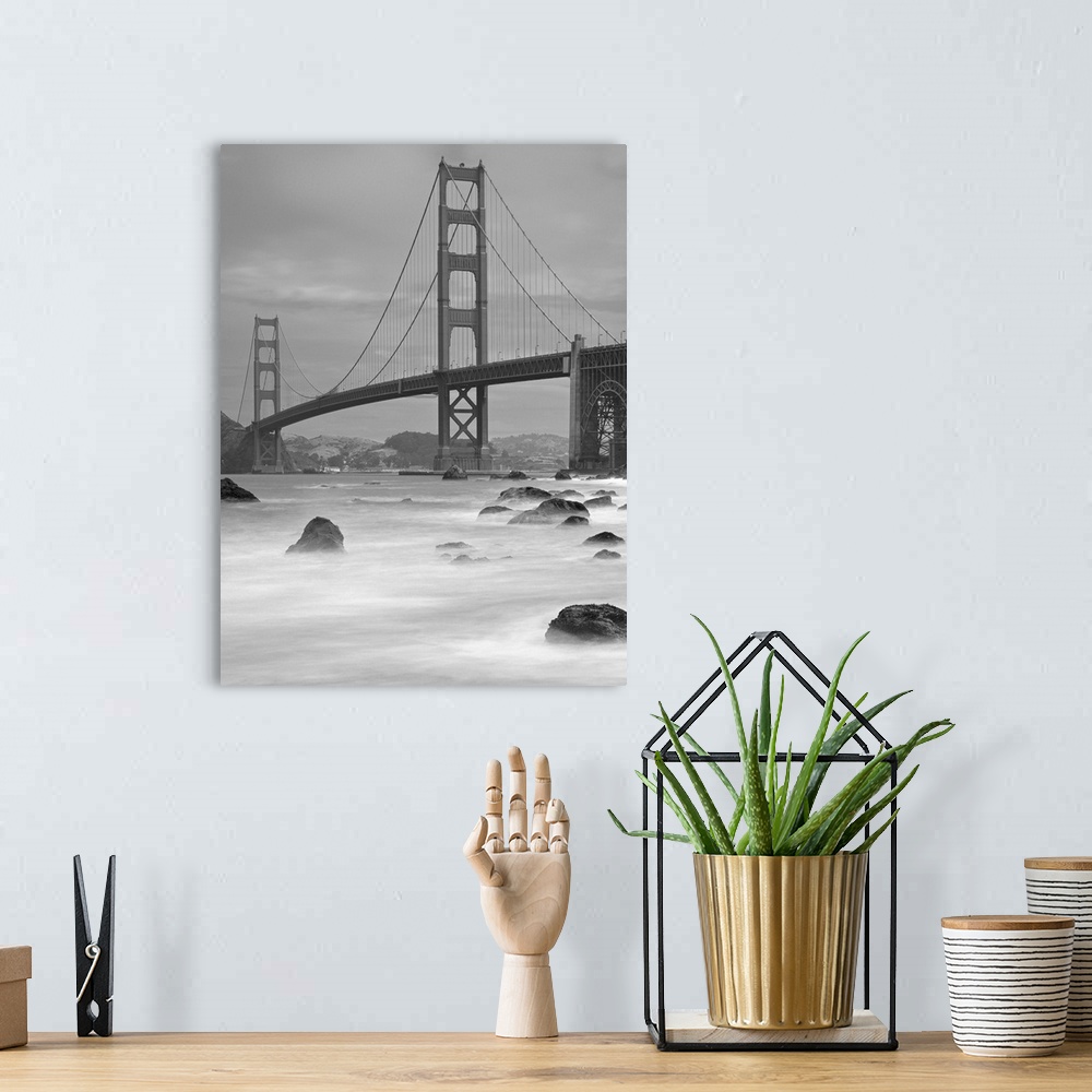 A bohemian room featuring Photo on canvas of the Golden Gate Bridge with wave breaking through rocks in the water.