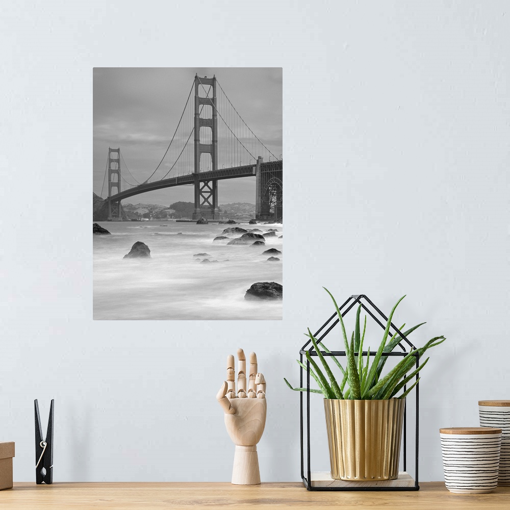 A bohemian room featuring Photo on canvas of the Golden Gate Bridge with wave breaking through rocks in the water.
