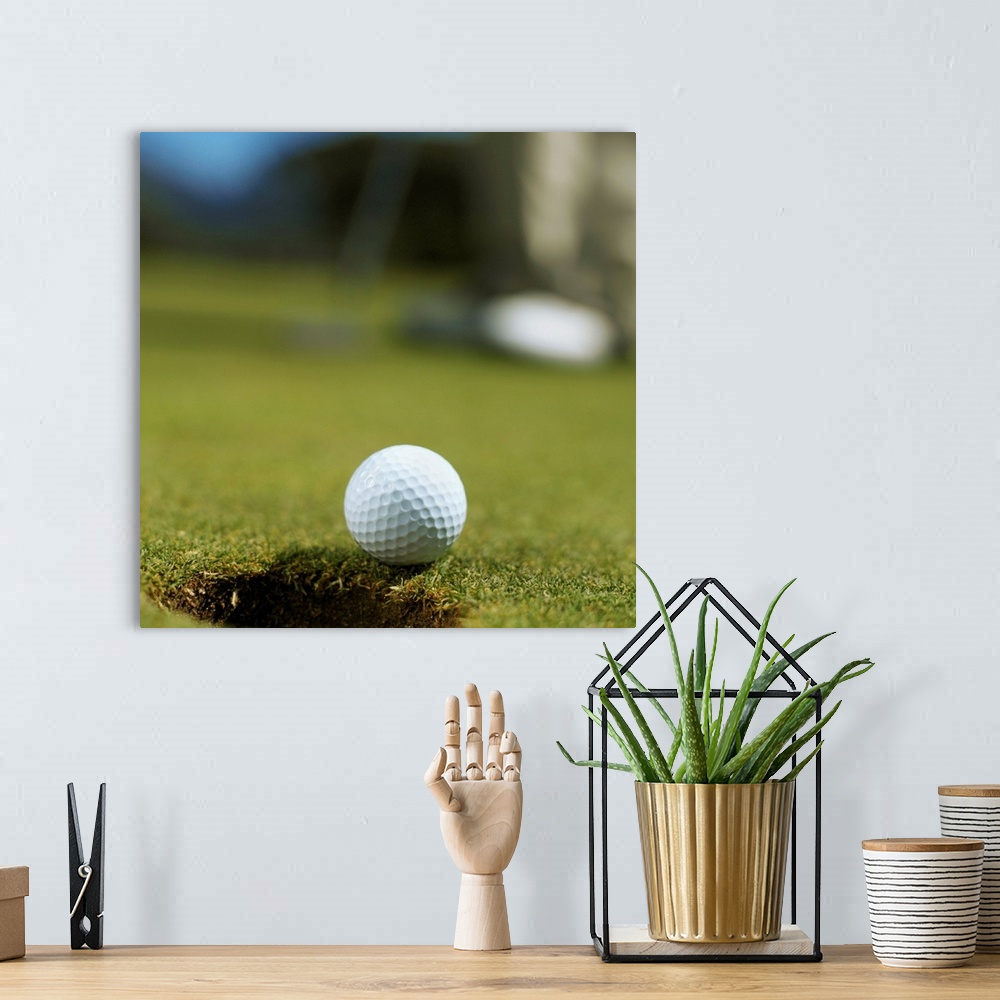 A bohemian room featuring Golf ball about to fall into the hole with a golfer in the background