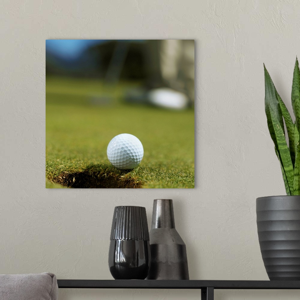 A modern room featuring Golf ball about to fall into the hole with a golfer in the background