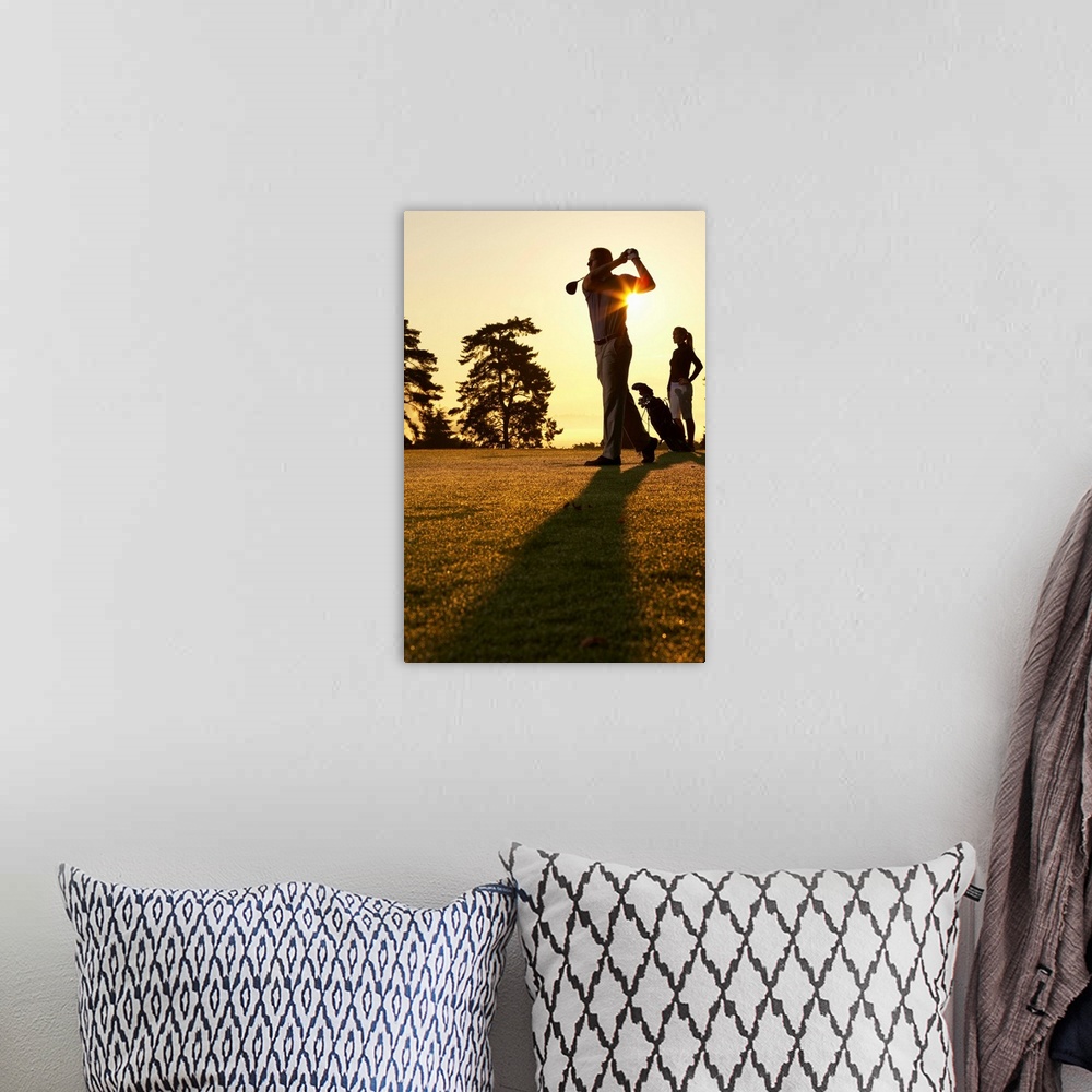 A bohemian room featuring Golfers playing golf at sunset, low angle view