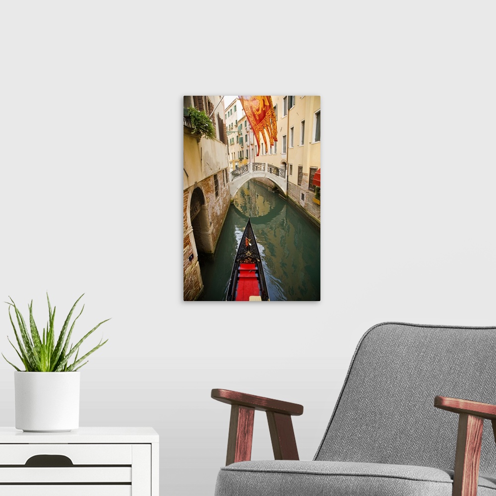 A modern room featuring Solitary gondola in narrow canal about to pass under a pedestrian bridge