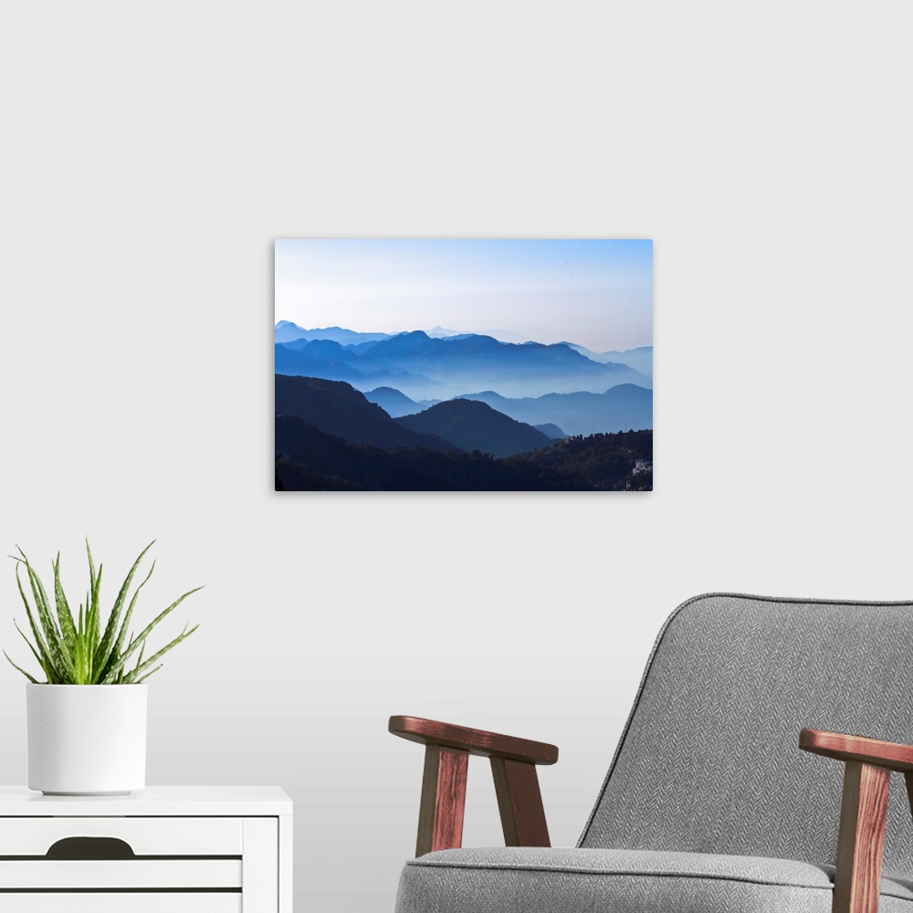 A modern room featuring Good layers of Mountains with clear blue sky, slight mist on mountains. Wide Angle.
