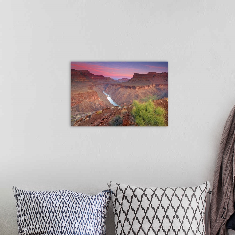 A bohemian room featuring The sun rises on the red rocks of the Grand Canyon as the Colorado River roars down below.
