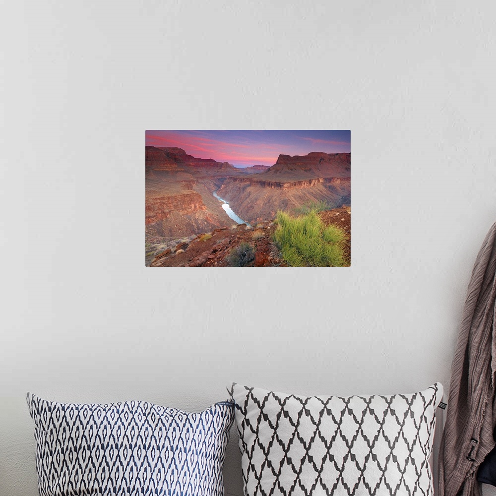 A bohemian room featuring The sun rises on the red rocks of the Grand Canyon as the Colorado River roars down below.