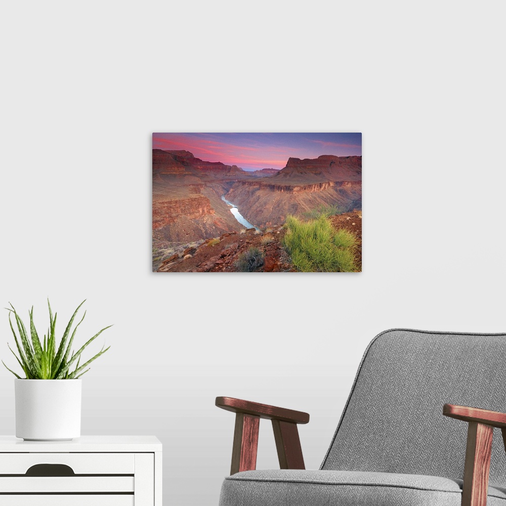 A modern room featuring The sun rises on the red rocks of the Grand Canyon as the Colorado River roars down below.