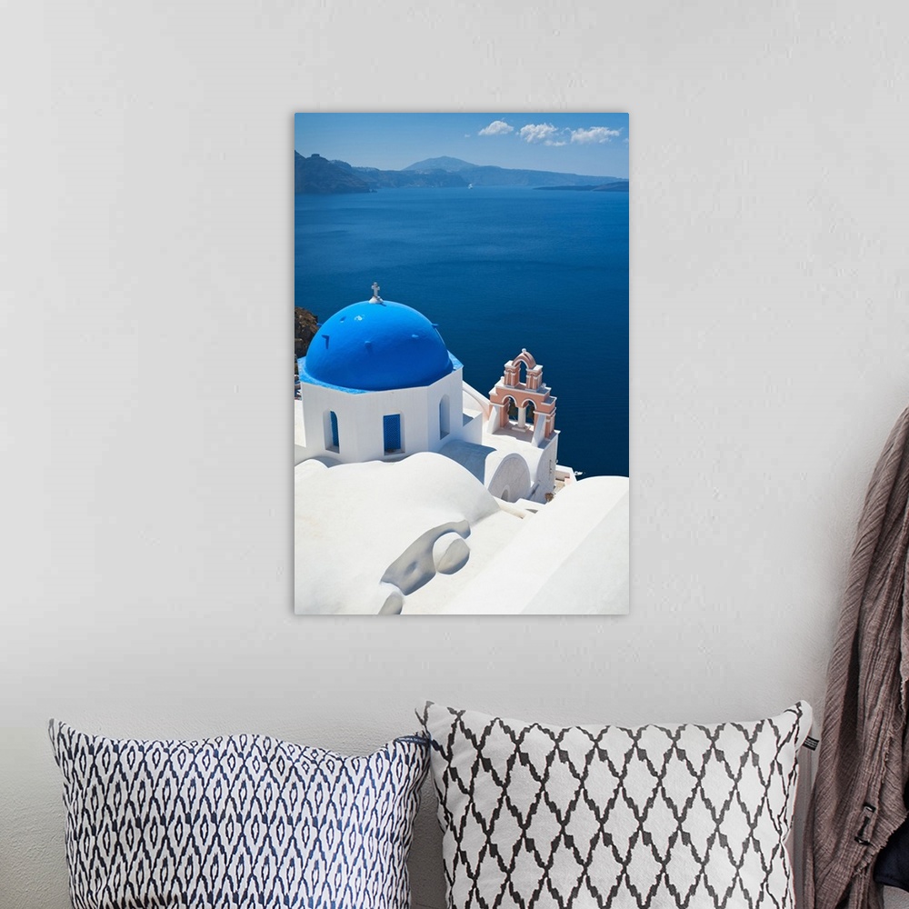 A bohemian room featuring Oversized, vertical, aerial photograph of the top of a church, overlooking blue waters over the c...