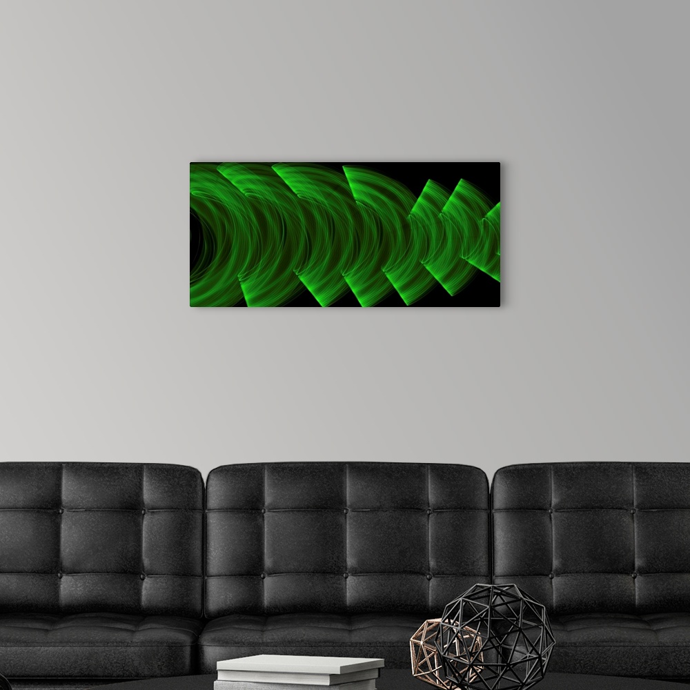 A modern room featuring Green light trails creating an abstract wave pattern on a black background