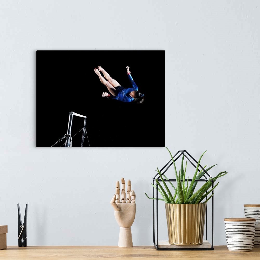 A bohemian room featuring Gymnast (16-17) dismounting uneven bars