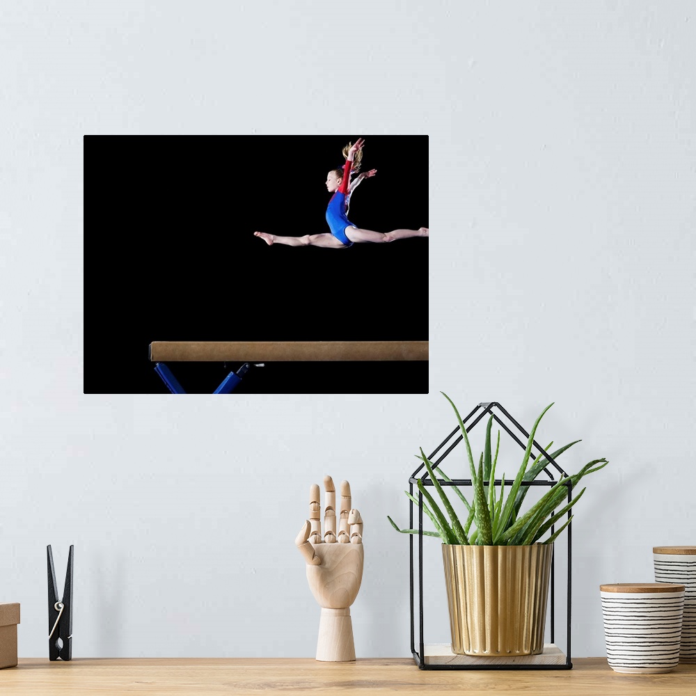 A bohemian room featuring Gymnast (9-10) leaping on balance beam