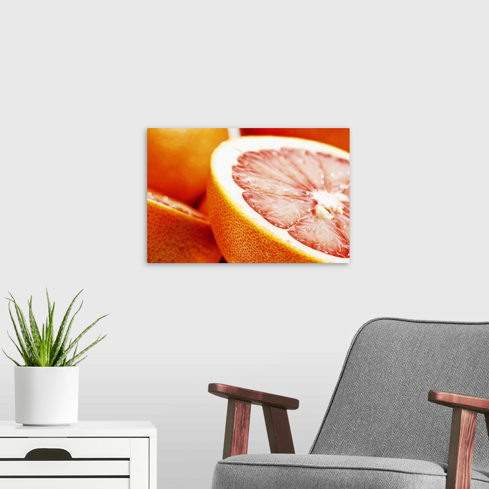 A modern room featuring Big, landscape, close up photograph of a grapefruit, sliced perfectly in half, the other half and...
