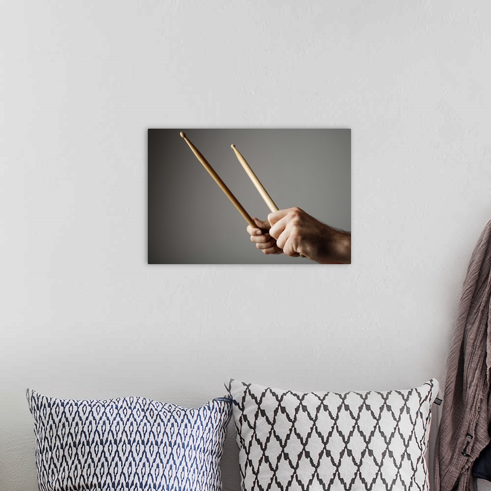 A bohemian room featuring Hands holding drumsticks