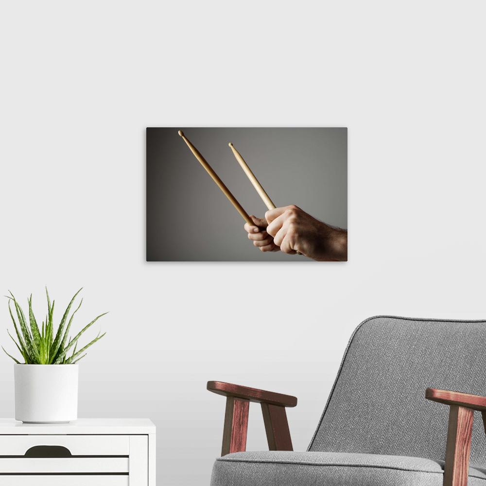 A modern room featuring Hands holding drumsticks