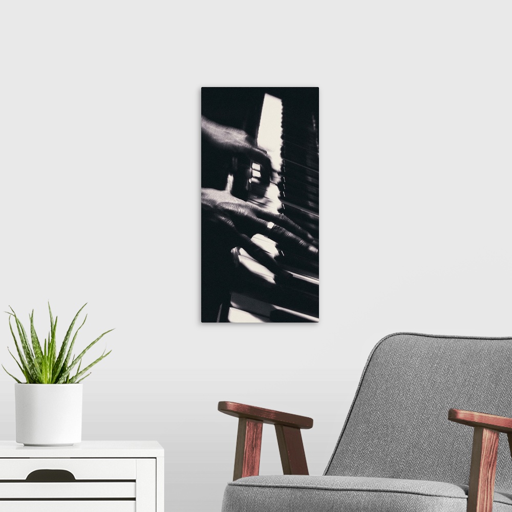 A modern room featuring Hands playing piano keys
