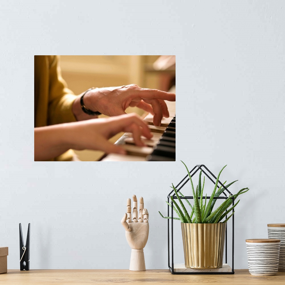 A bohemian room featuring Hands playing piano together