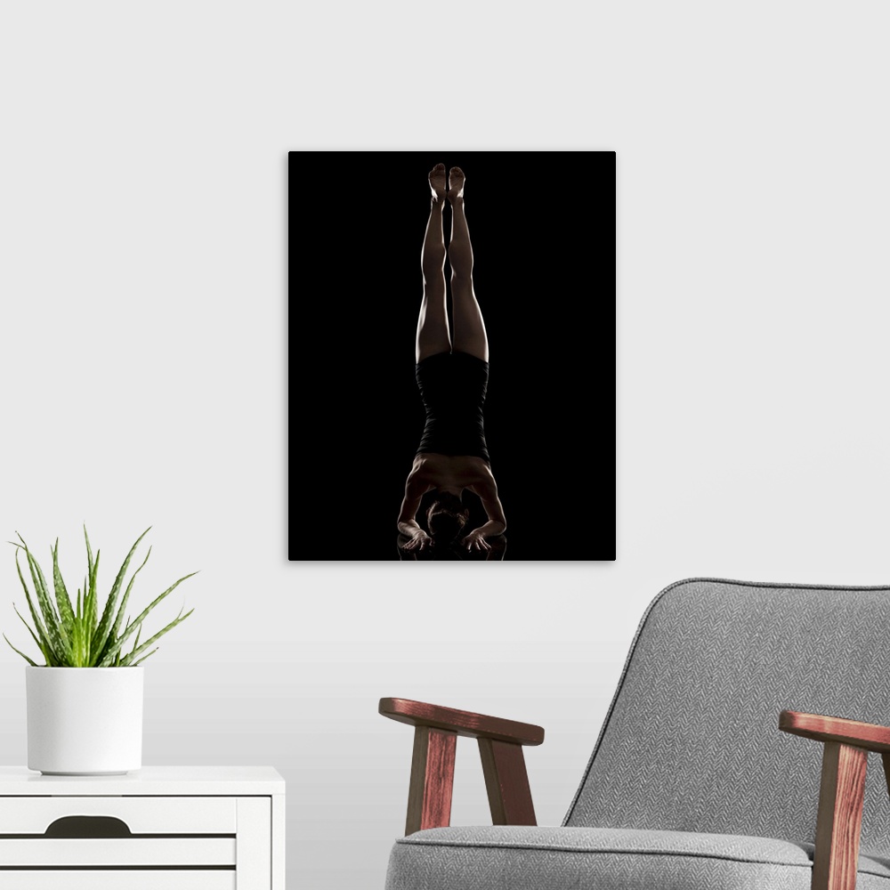 A modern room featuring Studio shot of woman practicing yoga.  Headstand Pose, Salamba Sirsasana