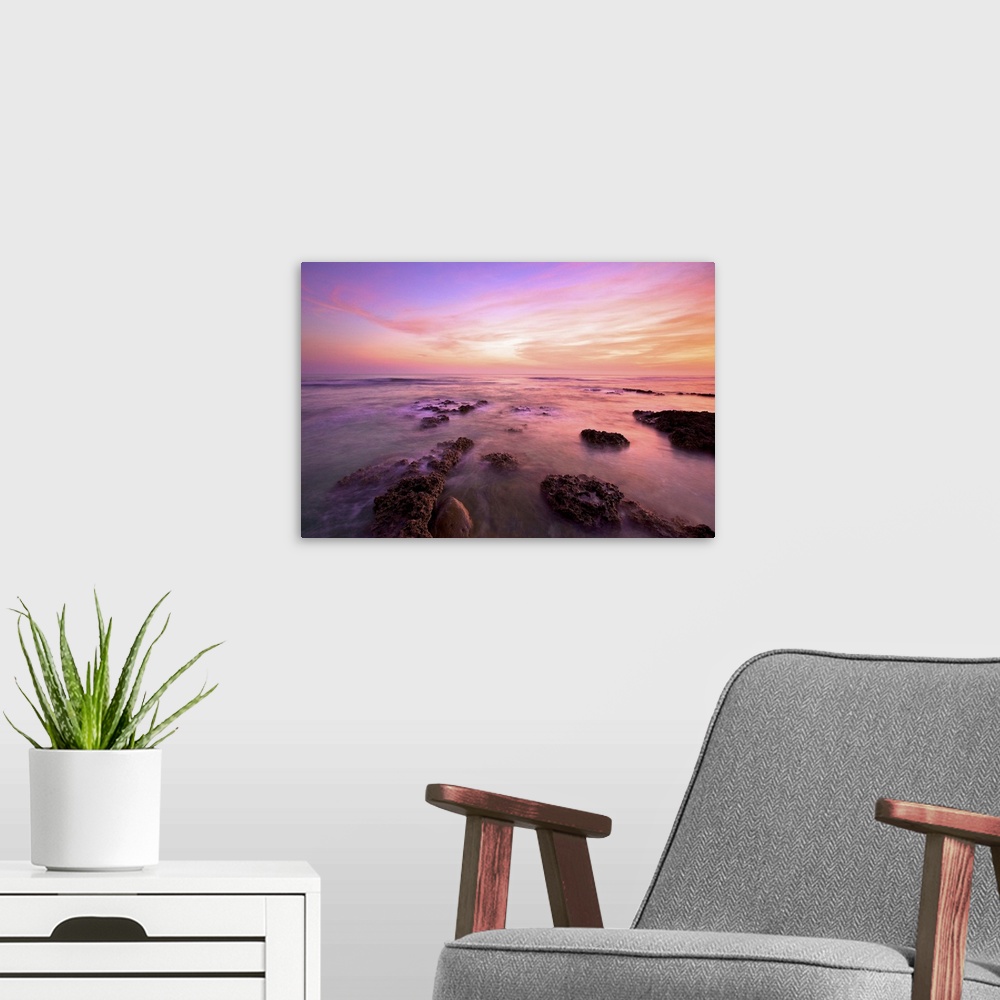 A modern room featuring Purple clouds spreading above Wanliton sky at dusk and sea water crashing on coral reefs; in Ping...
