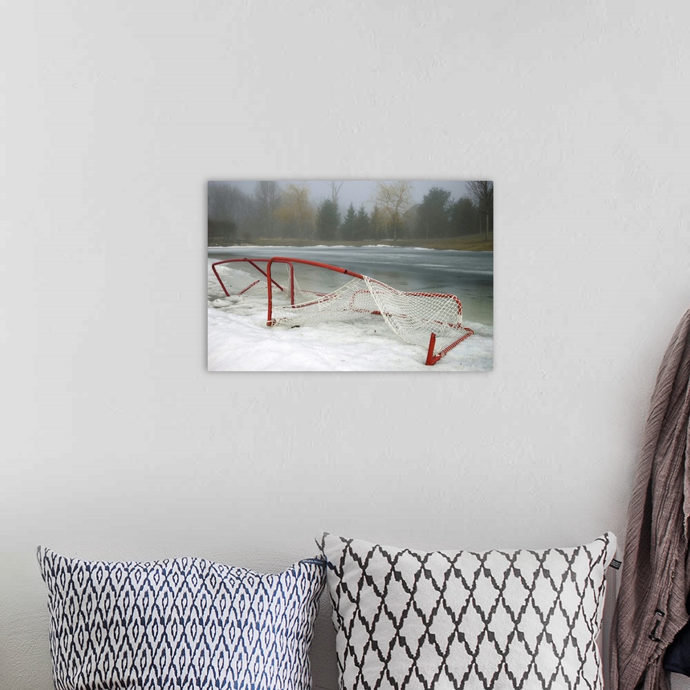 A bohemian room featuring Hockey net left from season in melting snow at Ottawa, Ontario, Canada.