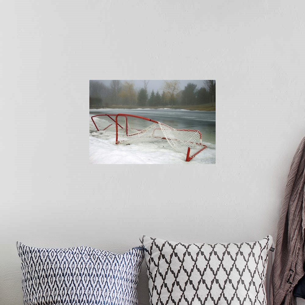 A bohemian room featuring Hockey net left from season in melting snow at Ottawa, Ontario, Canada.