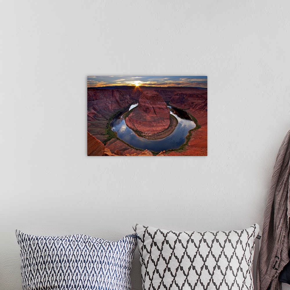 A bohemian room featuring Photograph of river circling huge rock formation at sunset under a cloudy sky.