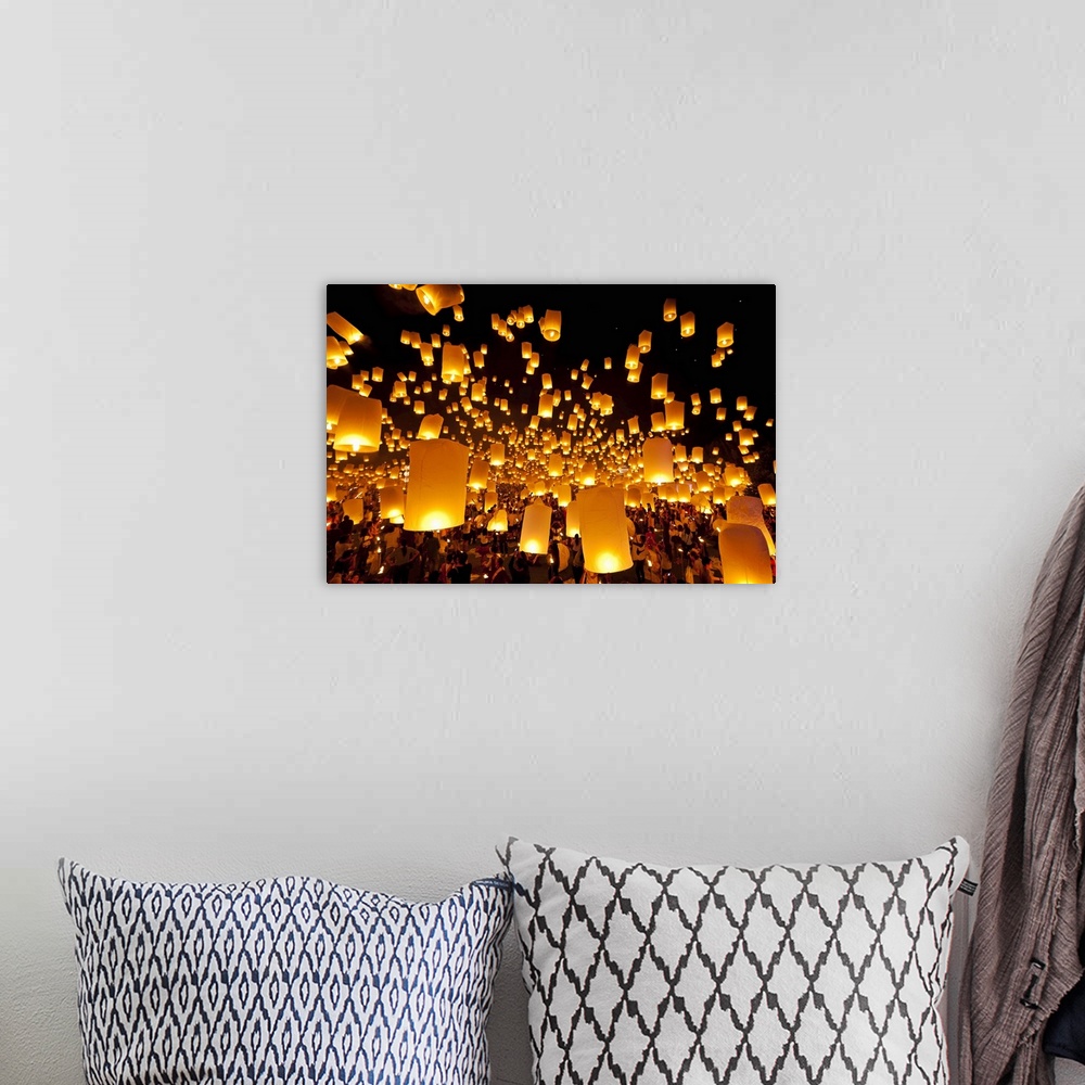A bohemian room featuring Big photo on canvas of fire lanterns being launched and some already in the sky floating away.