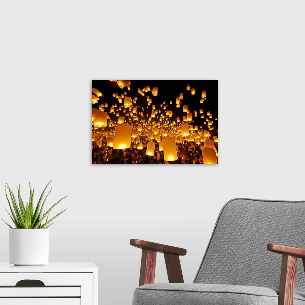 A modern room featuring Big photo on canvas of fire lanterns being launched and some already in the sky floating away.