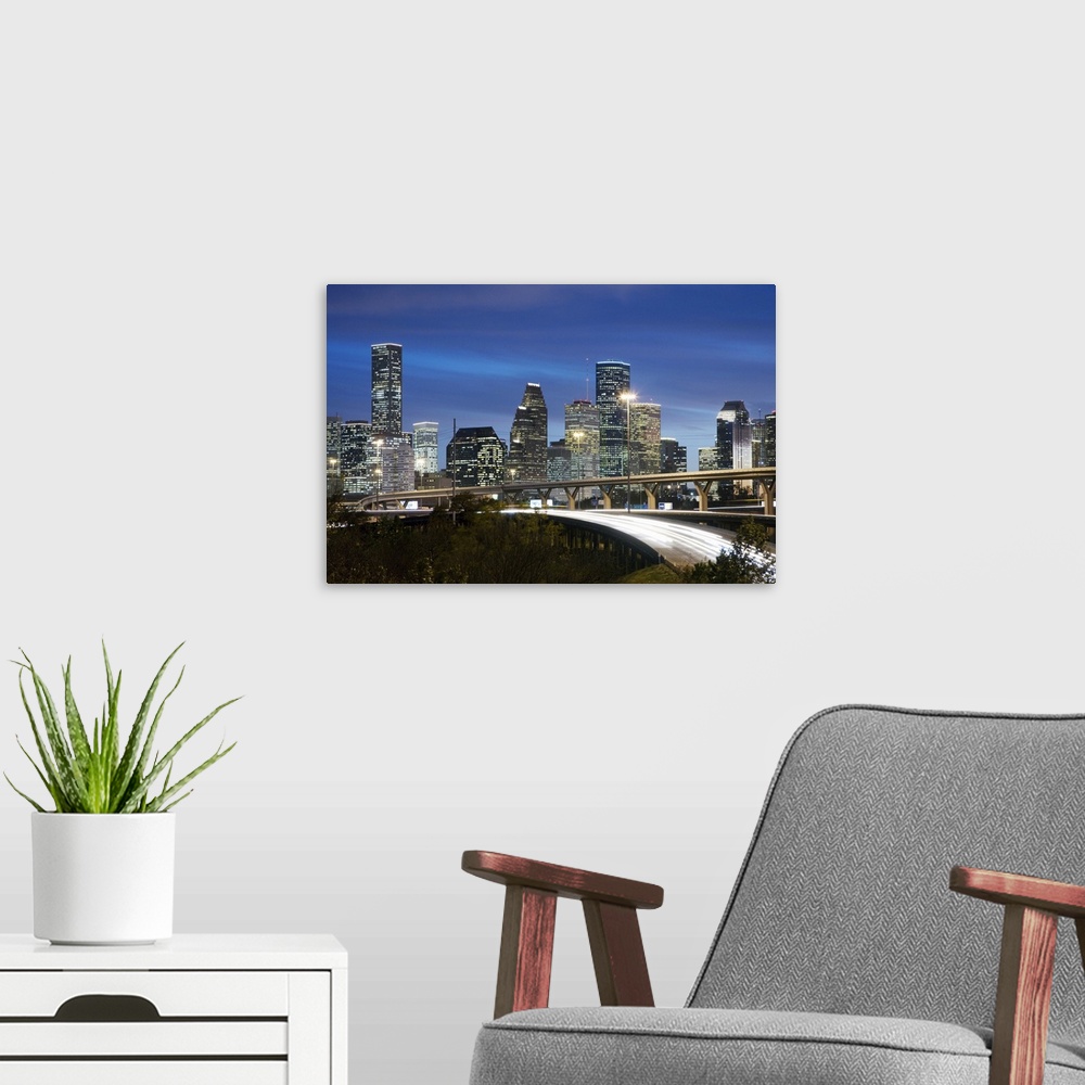 A modern room featuring Houston skyline at dusk