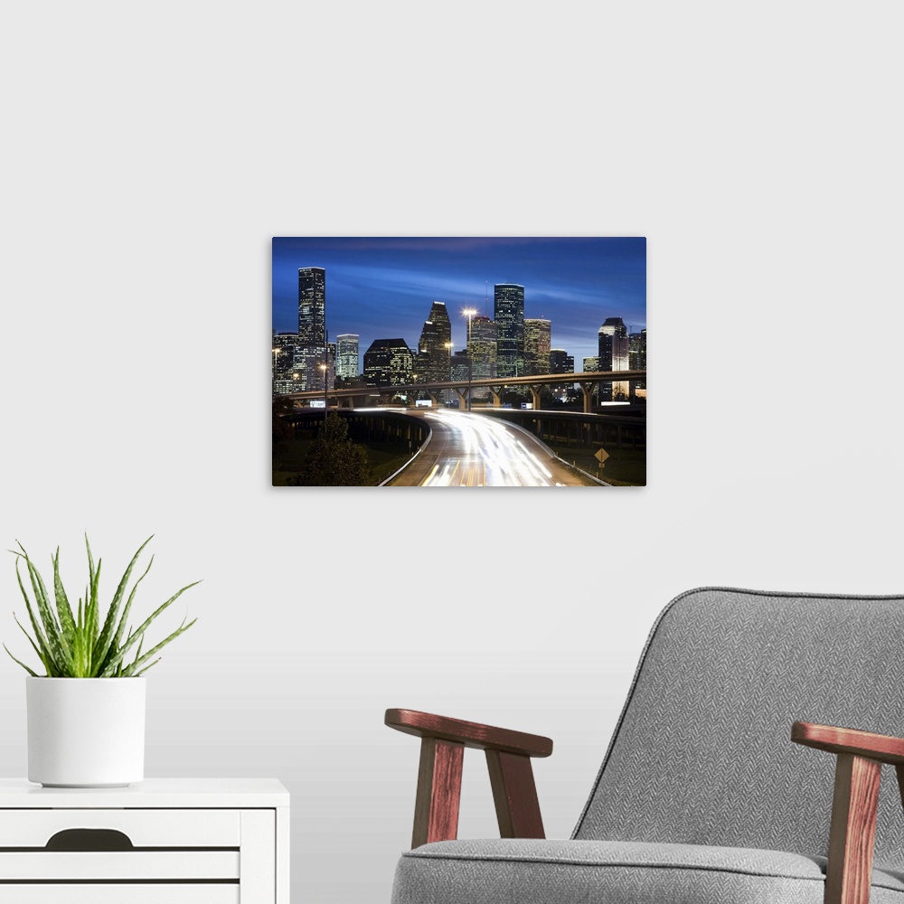 A modern room featuring Houston skyline at dusk with freeway in foreground