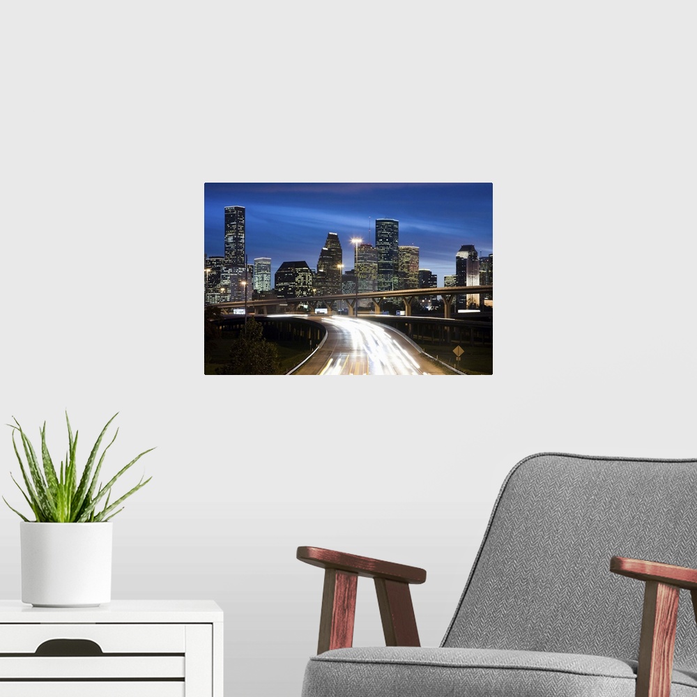 A modern room featuring Houston skyline at dusk with freeway in foreground
