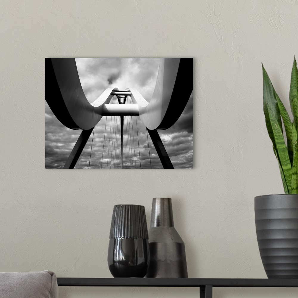 A modern room featuring A black and white photograph taken from below the infinity bridge in the UK and looking up to the...