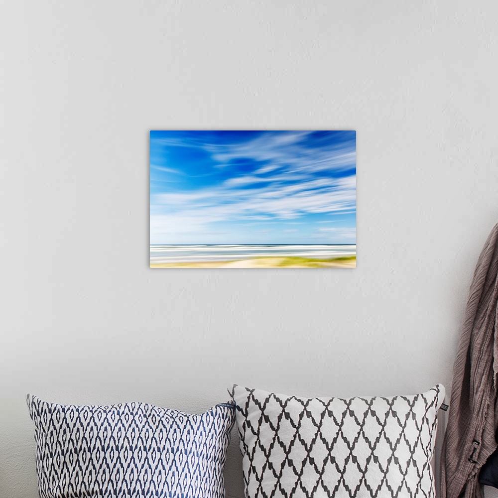A bohemian room featuring Intentional camera movement of ocean scene of with bright blue sky and wispy clouds. Teewah Beach...