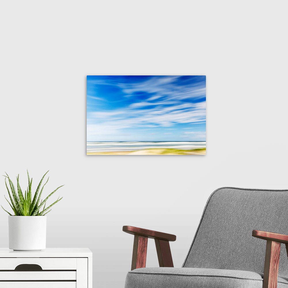 A modern room featuring Intentional camera movement of ocean scene of with bright blue sky and wispy clouds. Teewah Beach...