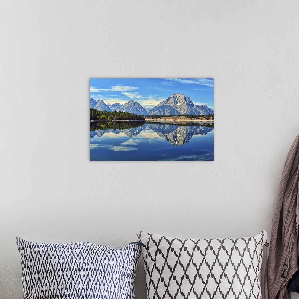 A bohemian room featuring A reflection of Mount Moran and the Teton mountain range in the still waters of Jackson Lake in G...