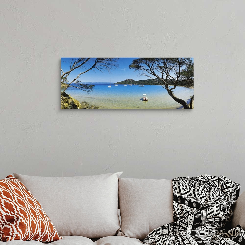 A bohemian room featuring This panoramic shot was taken looking out at a lagoon with boats in the water and trees on both s...
