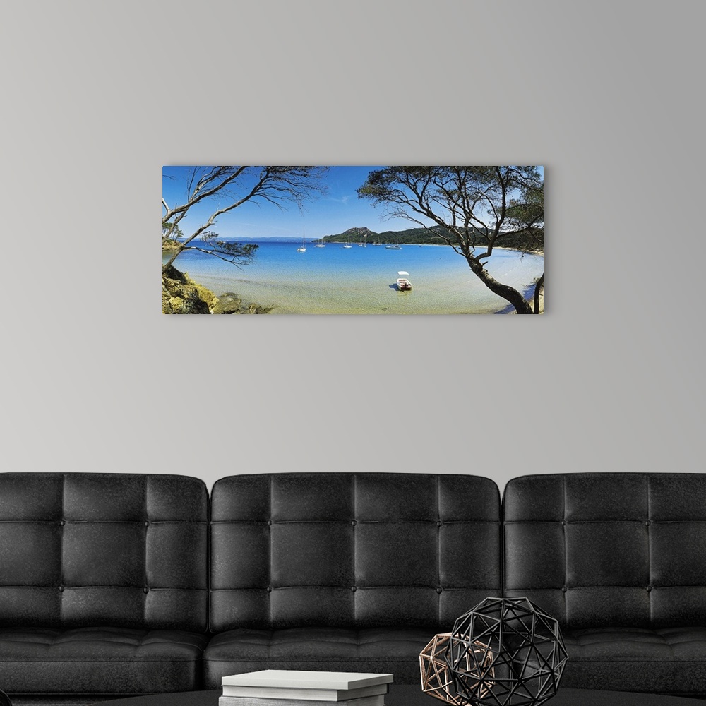 A modern room featuring This panoramic shot was taken looking out at a lagoon with boats in the water and trees on both s...