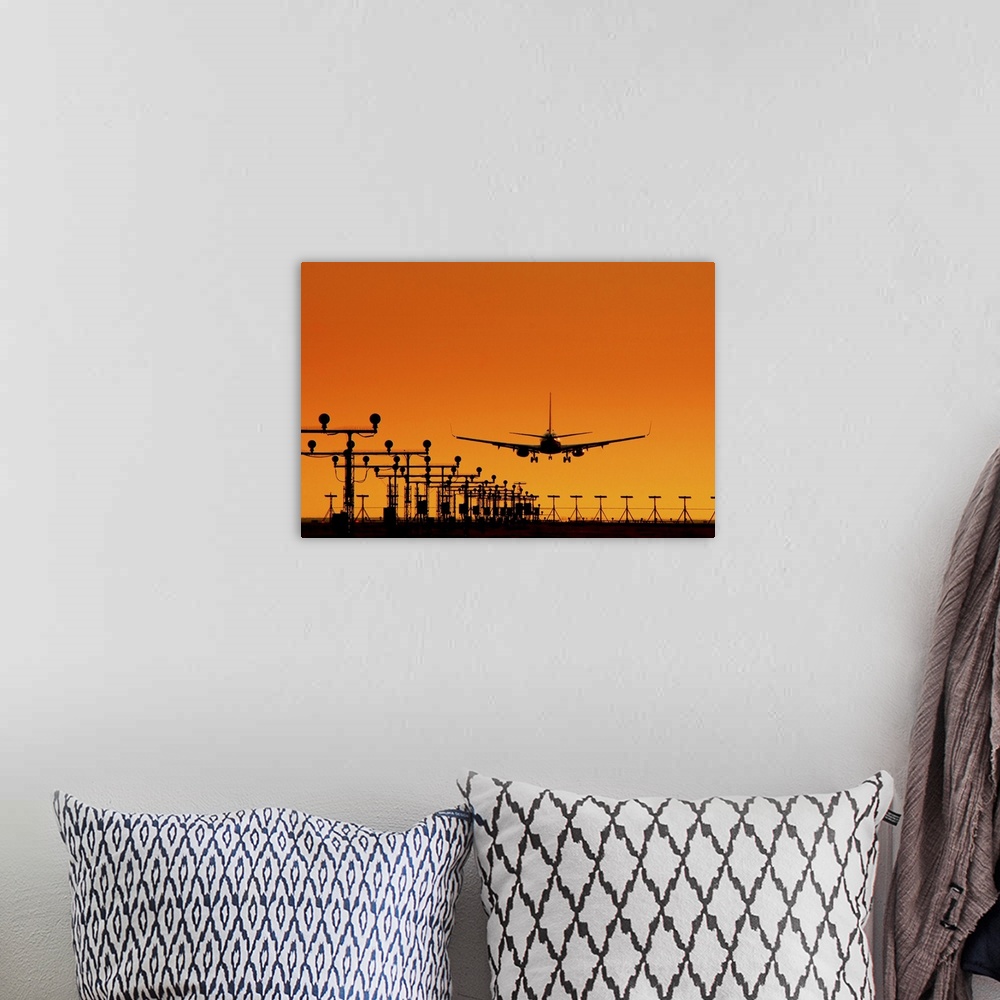 A bohemian room featuring Landing of an airplane at sunset
